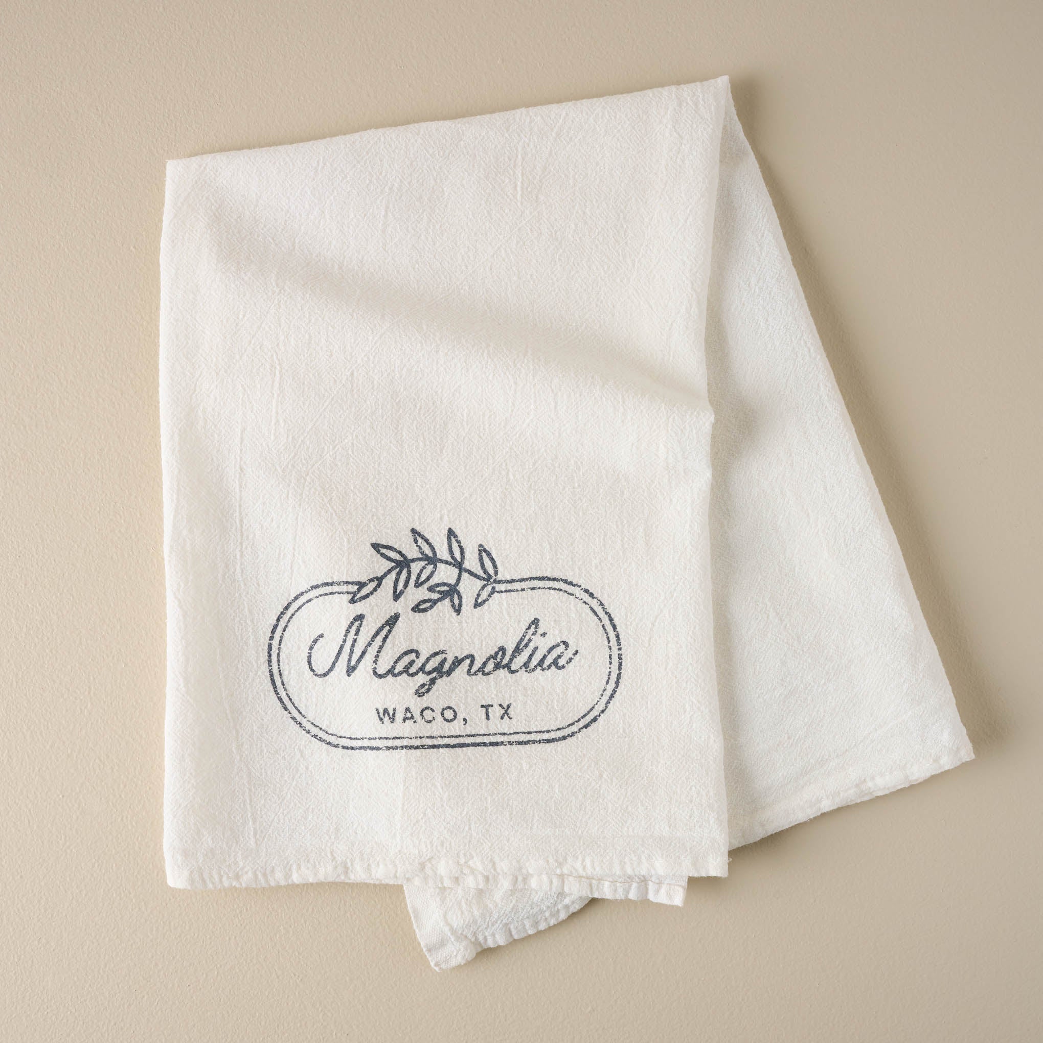 Magnolia Laurel Leaf Border Tea Towel On sale for $9.99, discounted from $16.00