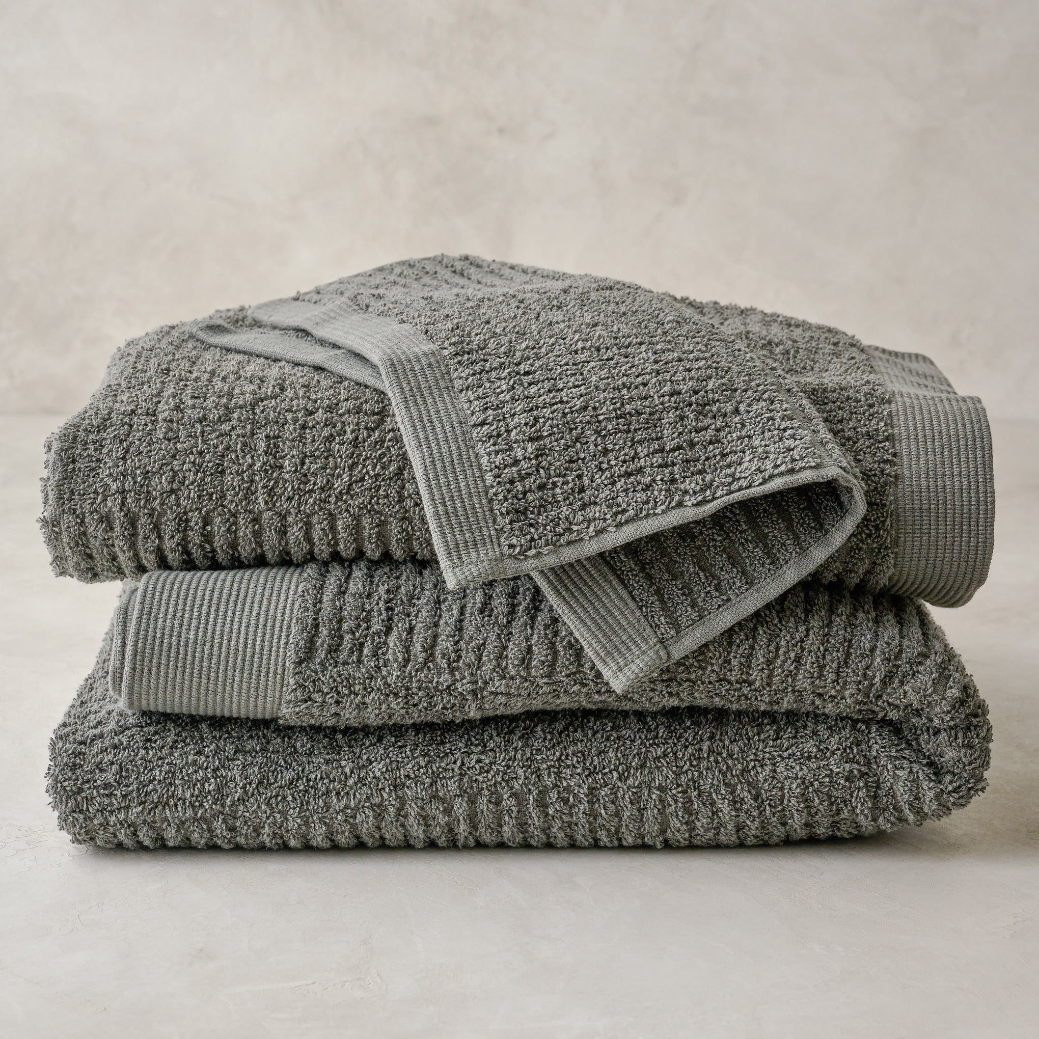 stacked olive green Textured bath towels and washcloth Items range from $12.00 to $42.00