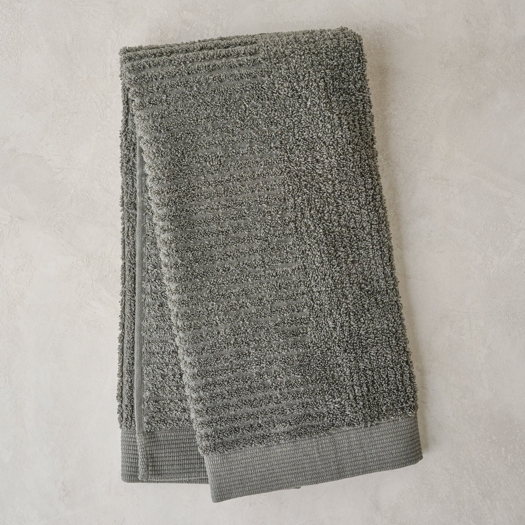 folded olive green textured hand towel