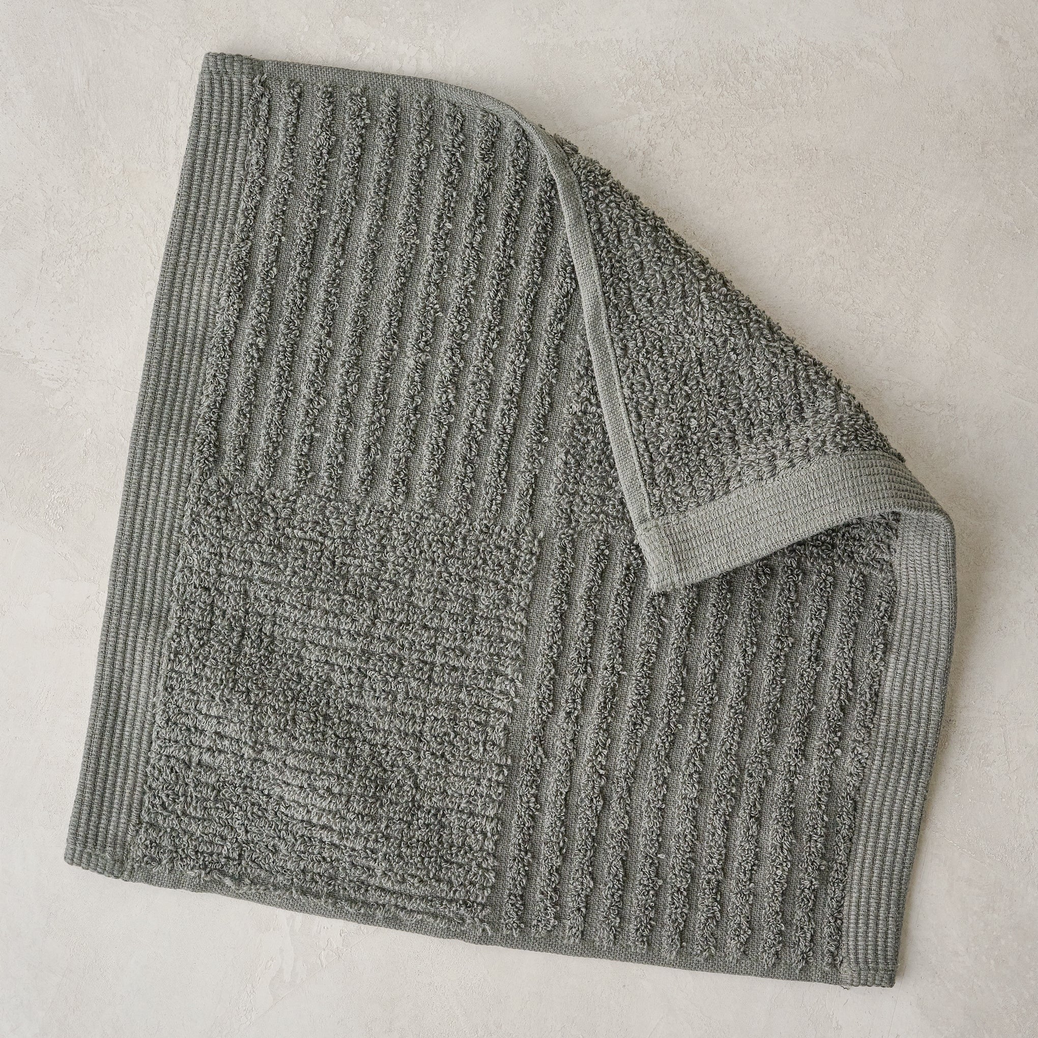 folded olive green textured bath washcloth