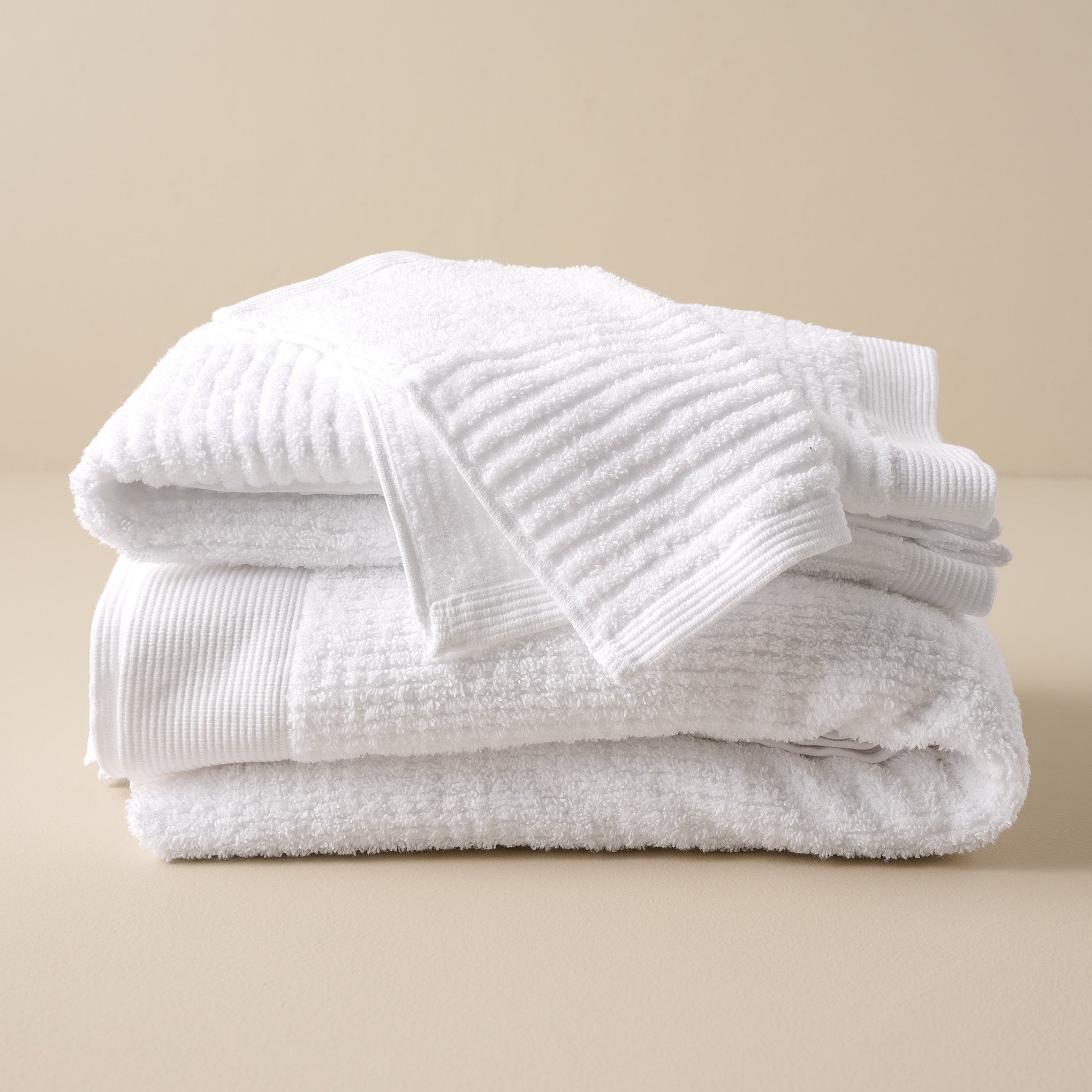 stacked White Textured bath towels and washcloth On sale with items ranging from $9.99 to $34.99, discounted from $12.00 to $42.00