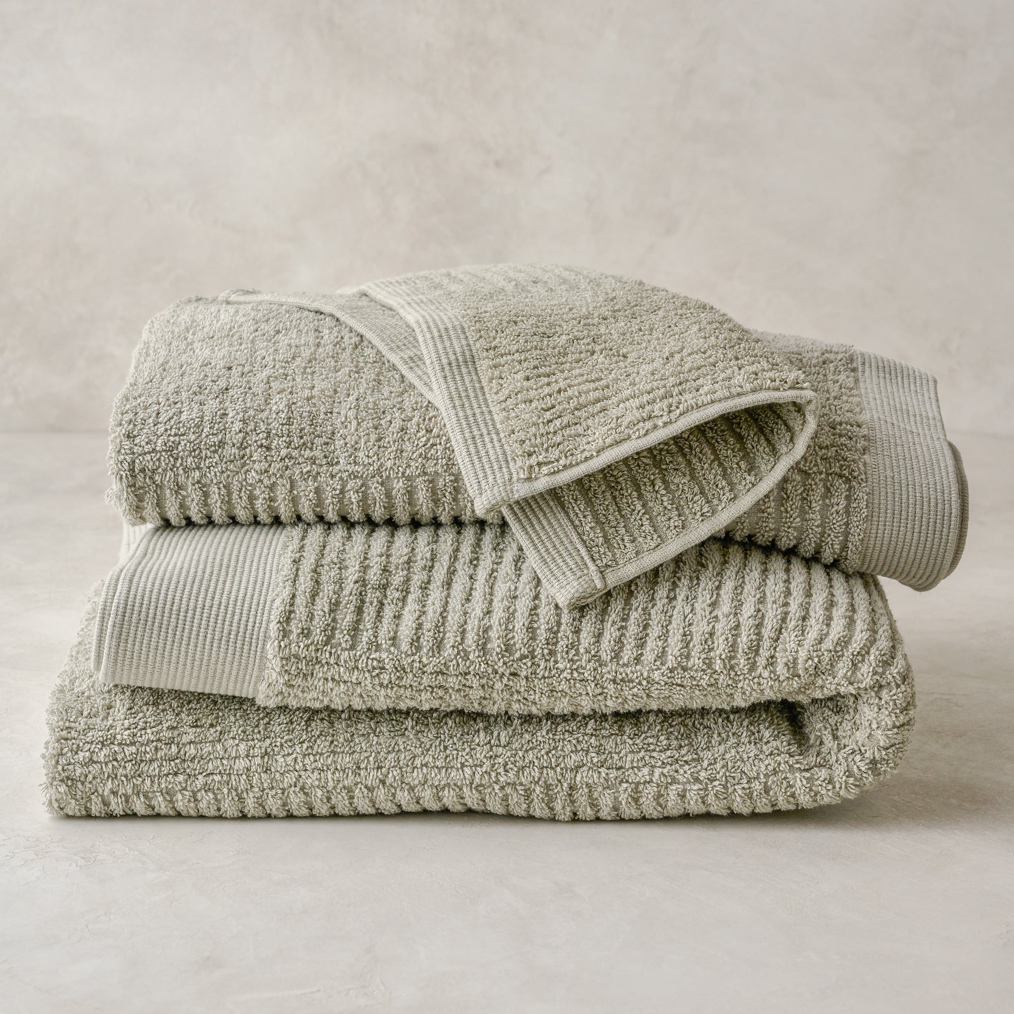 stacked eucalyptus green textured bath towels and washcloth Items range from $12.00 to $42.00