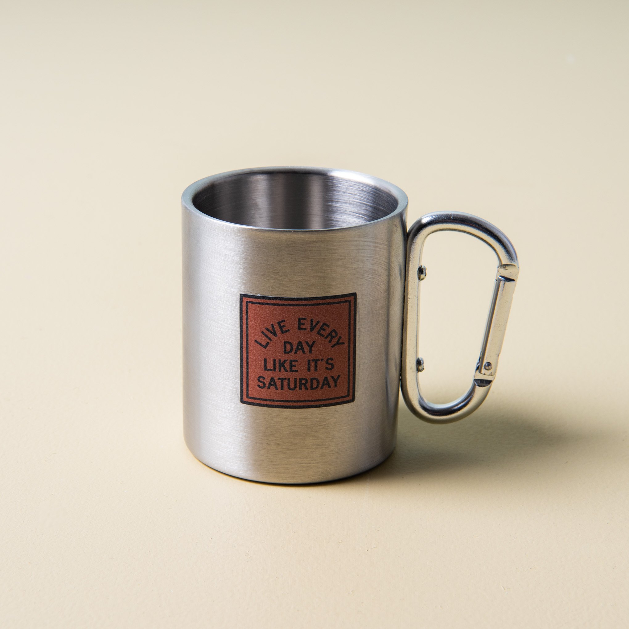 stainless steel mug with "live every day like it's saturday" printed stamp with silver carabiner handle $12.00
