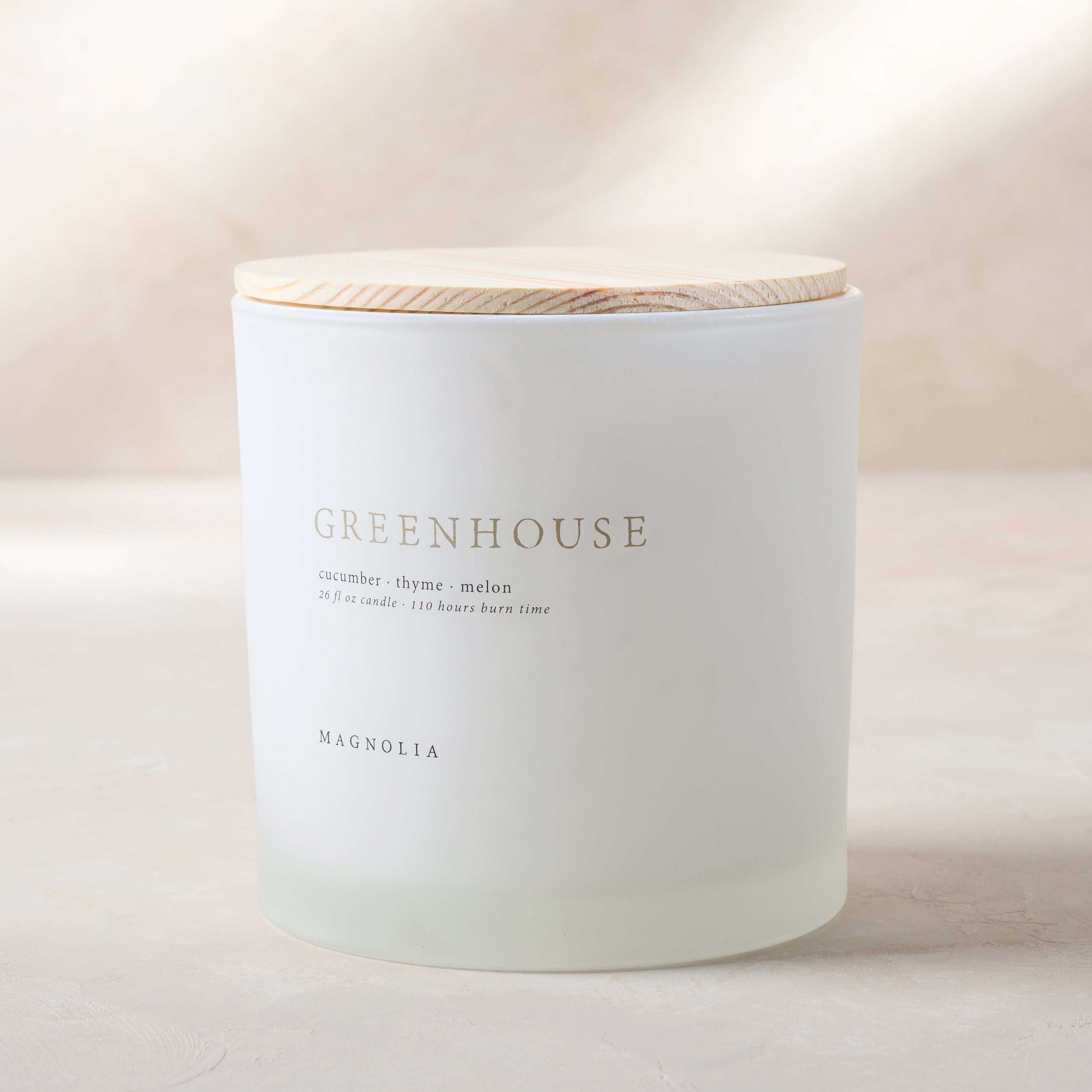 magnolia greenhouse candle with wood lid notes scents of cucumber thyme and melon