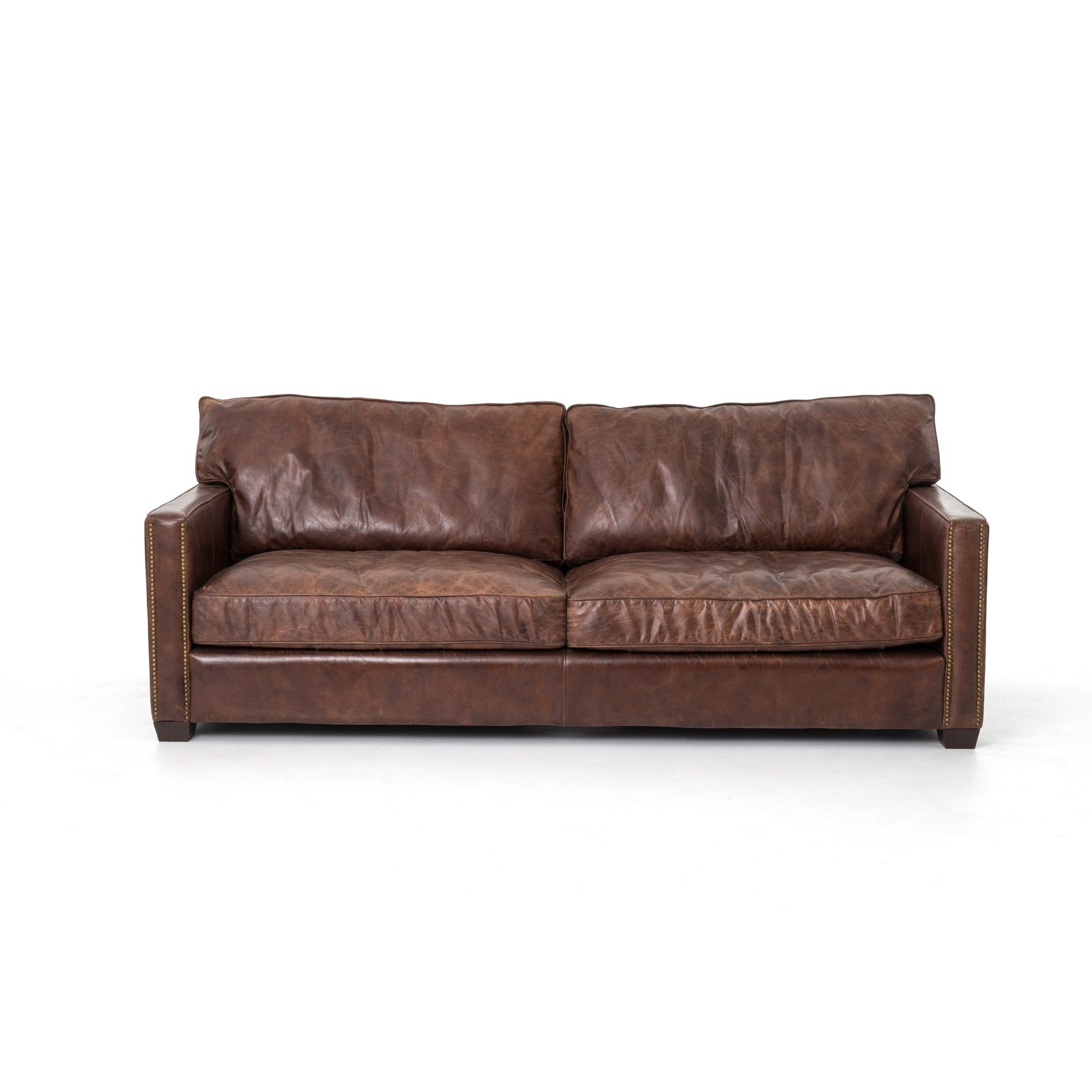 medium brown leather sofa with nailhead arms