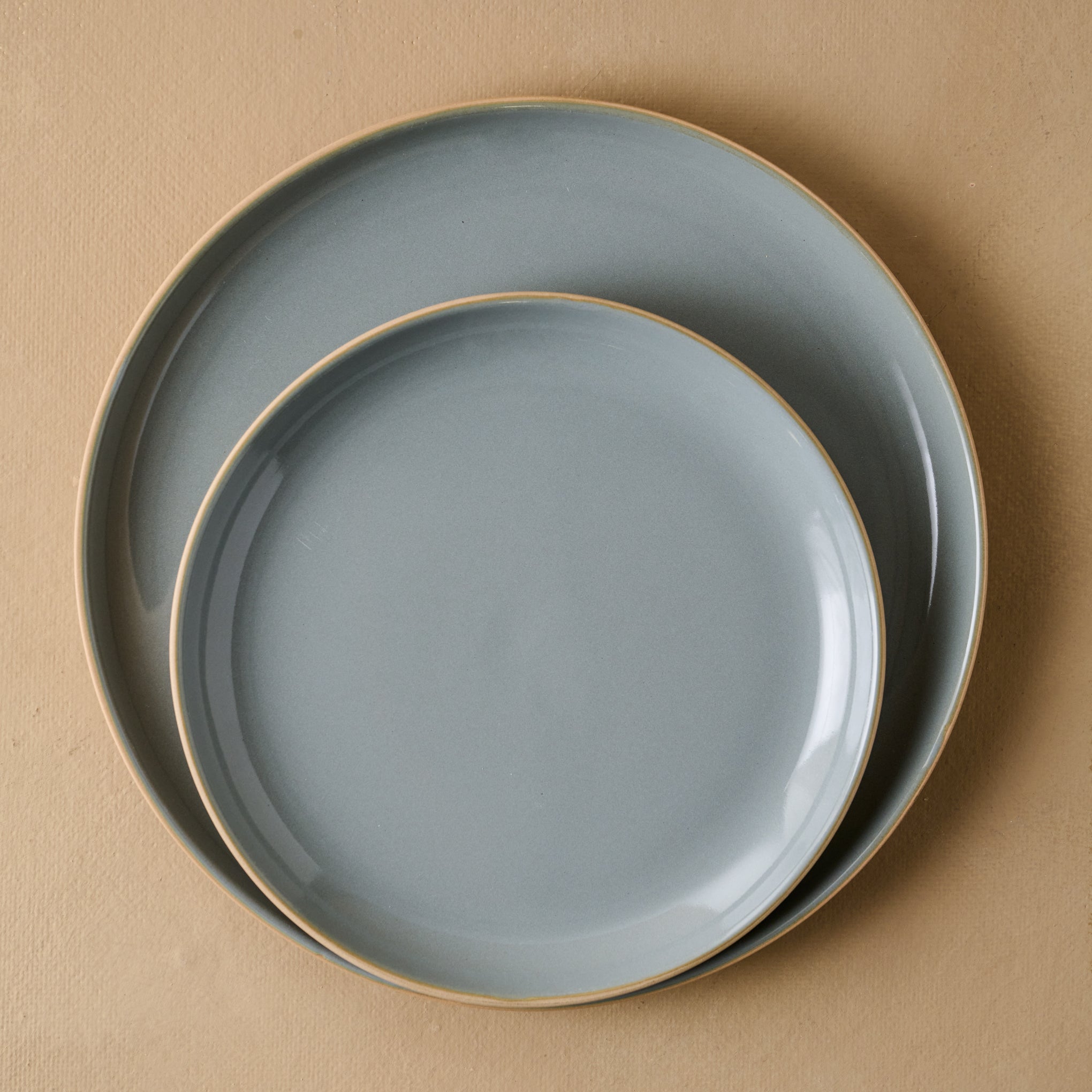 Lakelynn plates with a glazed blue gray interior and a tan exterior stacked atop one another.  Items range from $14.00 to $18.00