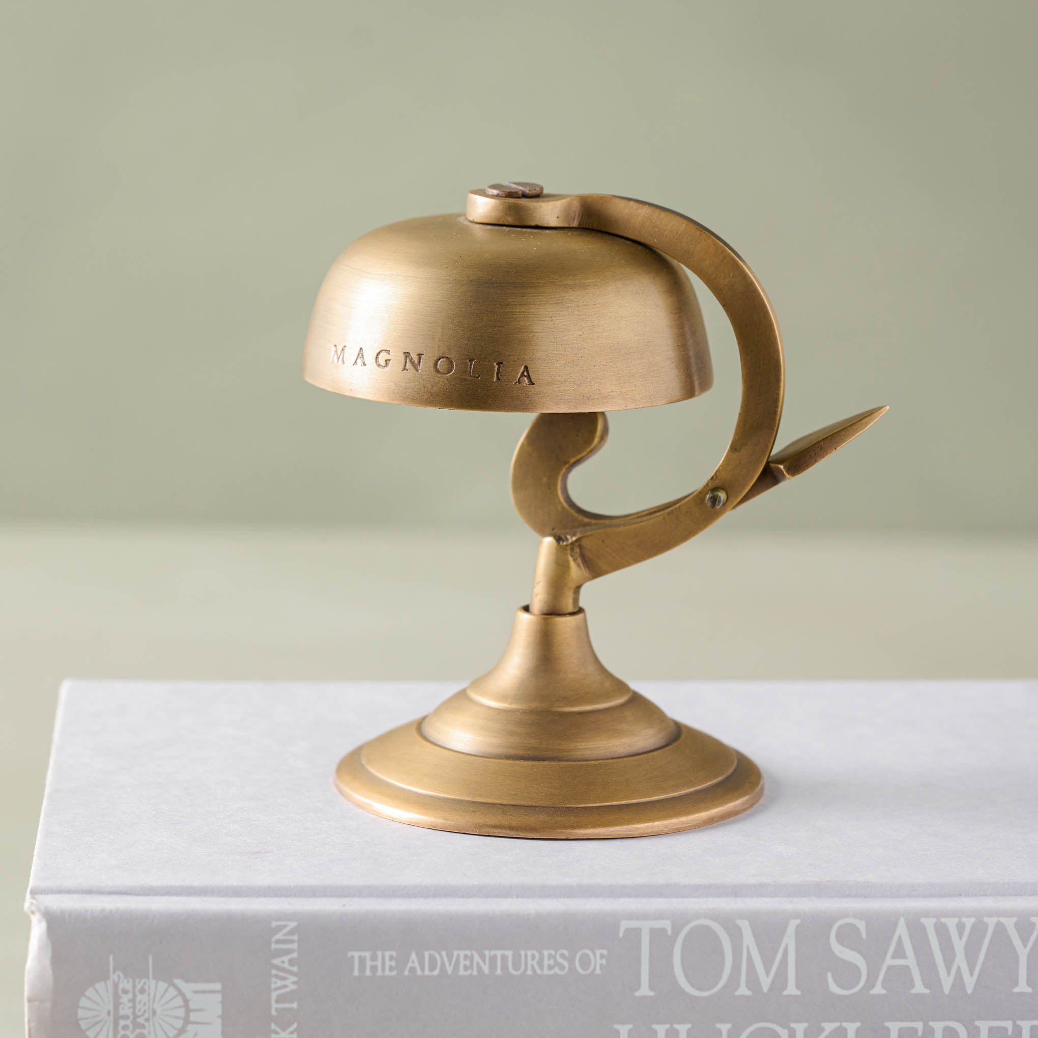 Antique Brass Bell on a coffee table book. 