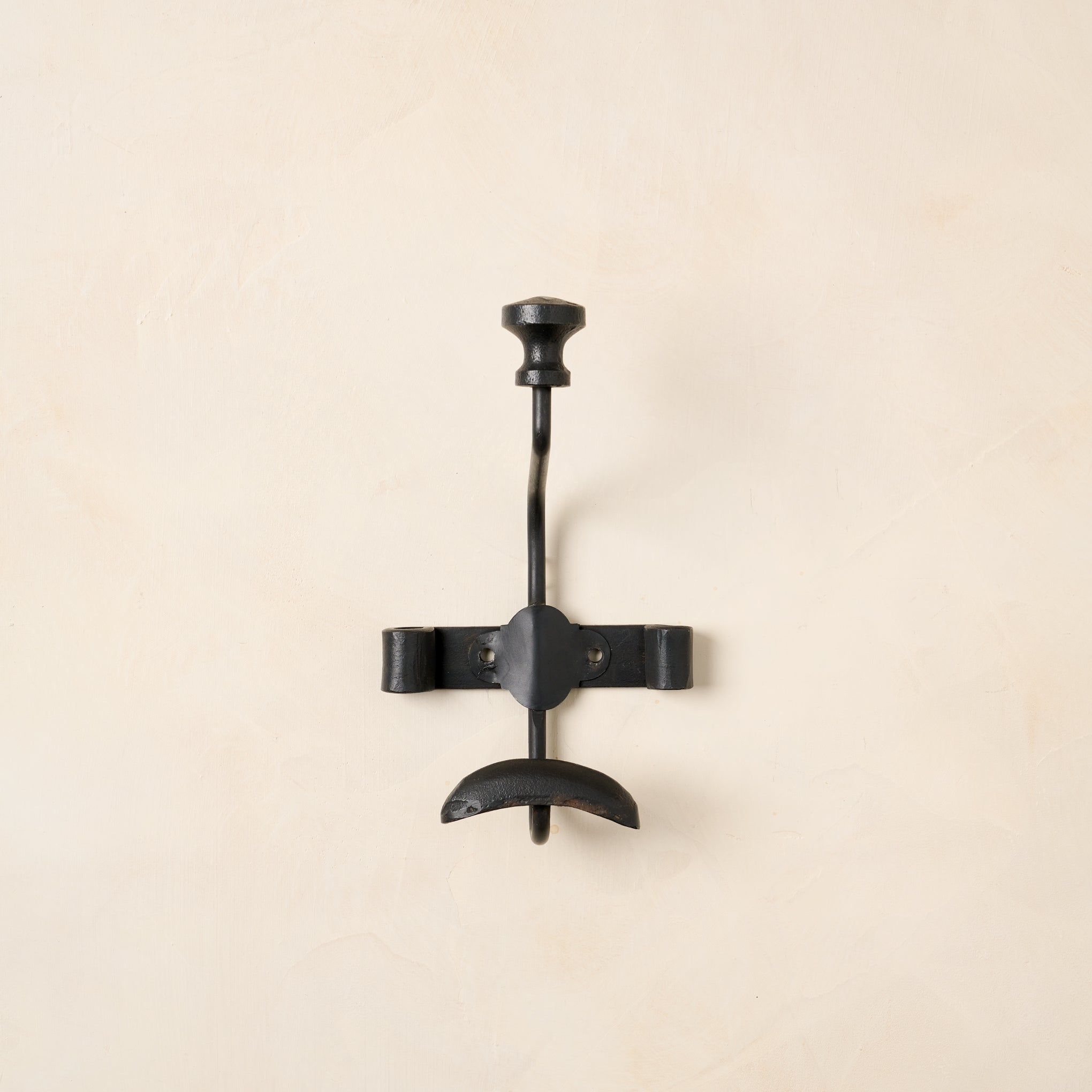 Close up of single duke metal wall hook. 