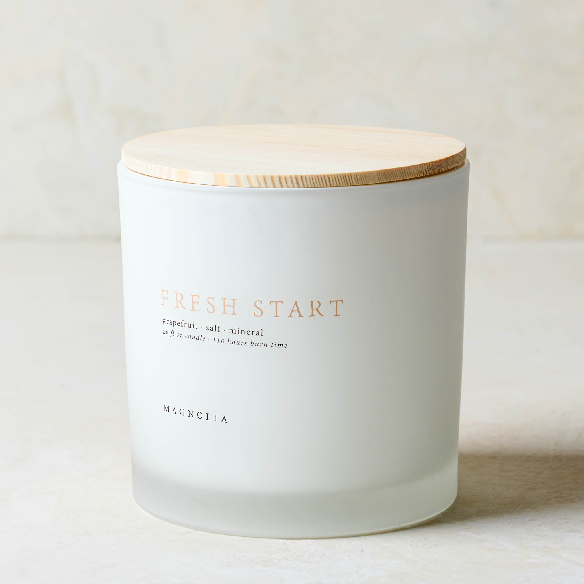 magnolia fresh start candle with wood lid notes scents of grapefruit salt and mineral