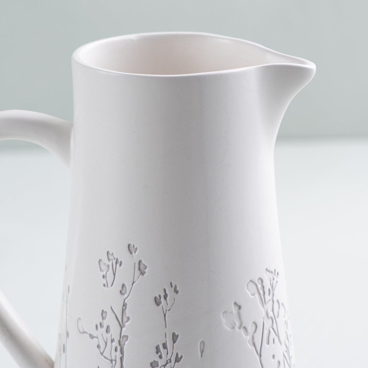 Multi-Colored Floral Arrangement in White Metal Pitcher Silicone