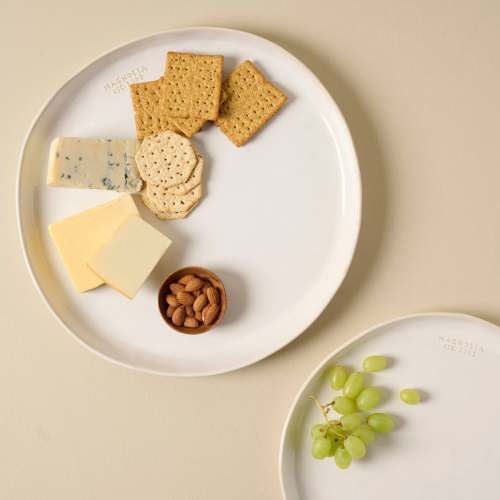 Magnolia Est. Ceramic Round Platter with cheese and crackers On sale with items ranging from $19.99 to $29.99, discounted from $28.00 to $38.00