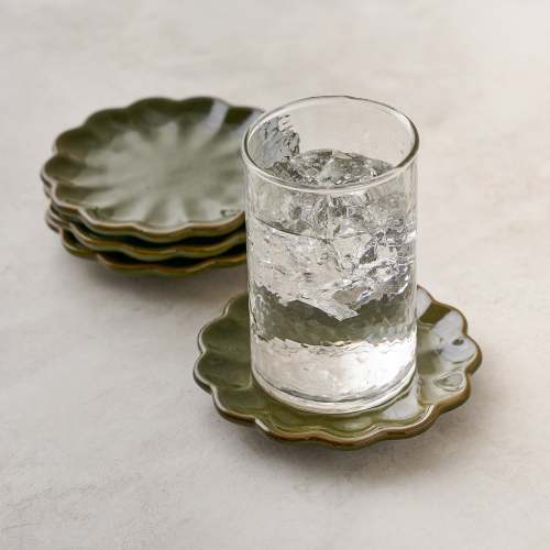 Sage Scalloped Edge Coaster Set of Four shown with glass of water $28.00